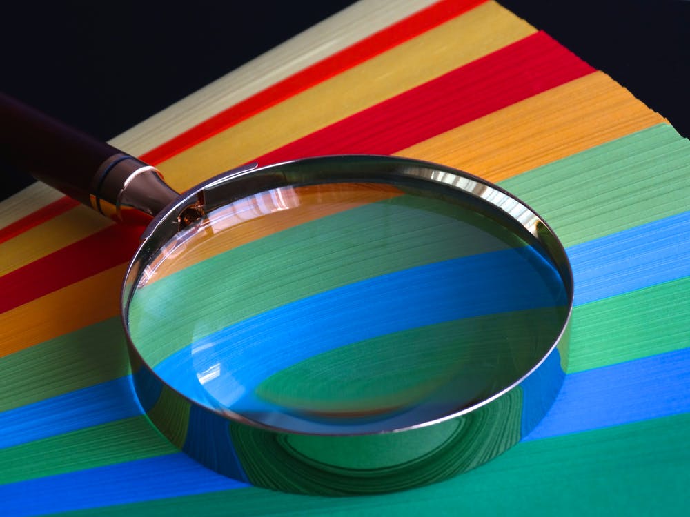 Magnifying glass atop coloured card